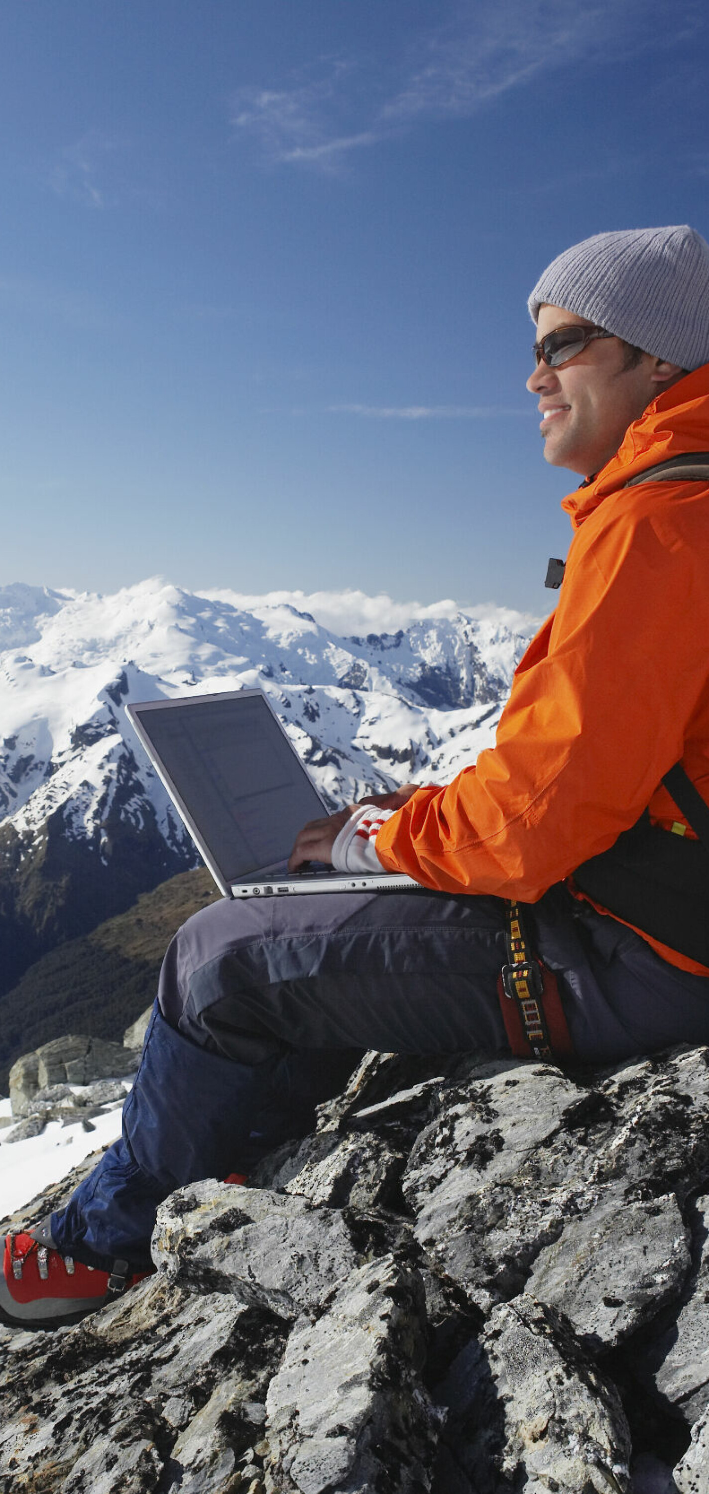 Side,View,Of,A,Male,Mountain,Climber,Using,Laptop,On