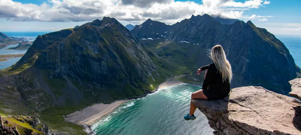 Adventurous,Woman,Looking,Down,At,Kvalvika,Beach,In,Lofoten,,Norway